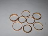 a pile of gold rings on a white surface