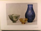 two vases and a bowl sitting on a table