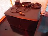 a brown speaker sitting on top of a table next to a laptop