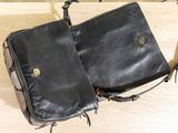 a black purse sitting on top of a wooden table