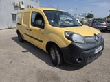 the small yellow van is parked in front of a building