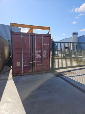 a red shipping container sitting in the middle of a parking lot