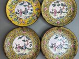 four yellow and blue plates with flowers and birds on them
