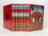 trois livres dans une boîte rouge posée sur une surface blanche