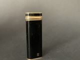 a close up of a black and gold lighter sitting on a table