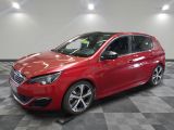 une voiture rouge garée dans un garage au sol en damier