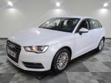 une Audi blanche garée sur un sol à damier dans un garage
