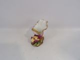 a small vase with a flower inside of it on a white surface