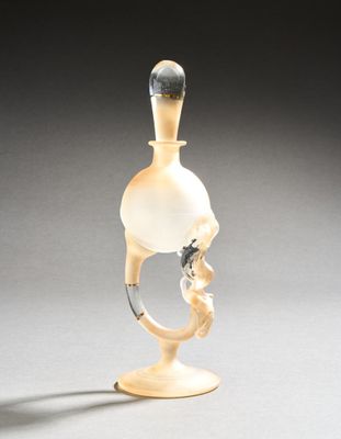 a glass bottle with a handle on a stand
