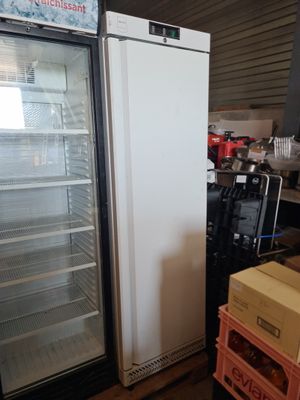un réfrigérateur posé à côté d'une pile de cartons