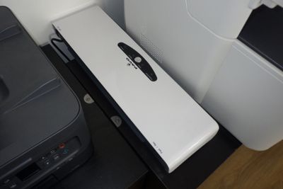une image représentant une imprimante posée sur un bureau, à côté d'une autre imprimante