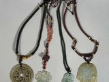 trois colliers composés de perles de différentes couleurs et ornés de breloques