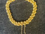 un bracelet à chaîne en or avec une breloque en forme de cœur