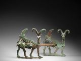 a group of three bronze figurines of animals and a goat