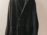 un blazer noir suspendu à un cintre accroché au mur