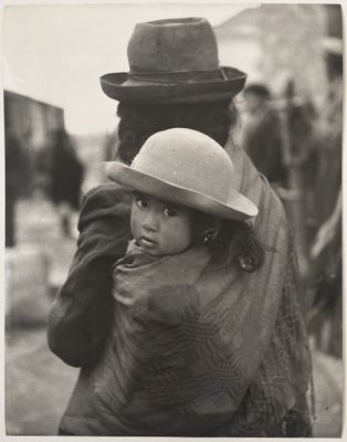photographie en noir et blanc d'une femme portant un enfant sur le dos