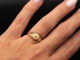 a woman ' s hand with a gold ring on it ' s finger