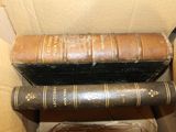 two old books sitting on top of each other in a box