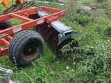 a tractor with a plow attached to it in the grass
