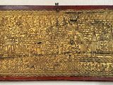 an old gold plate with a painting on it hanging on a wall