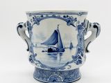 un vase bleu et blanc orné d'un voilier