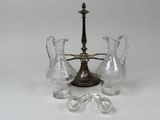 three glass vases and a candle holder on a white surface
