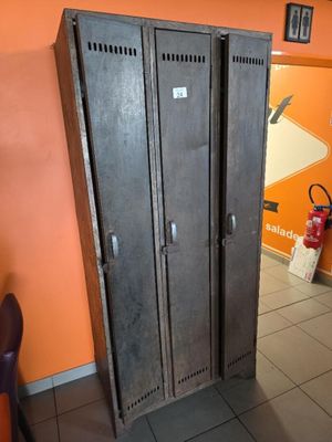 un casier métallique dans un coin d'une pièce aux murs orange