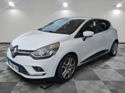 une voiture blanche est garée dans une pièce au sol à carreaux