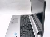 a silver laptop with a black keyboard on a white surface