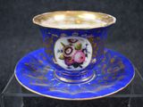 blue and gold cup and saucer with a floral design