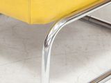 a yellow leather bench with chrome legs on a white floor