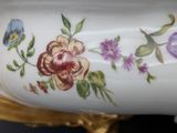 a close up of a vase with flowers painted on it