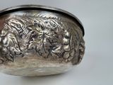 a silver bowl with a design on it on a table