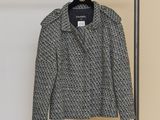 a black and white jacket hanging on a hanger in a room