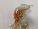 a glass bird that is sitting on a white surface