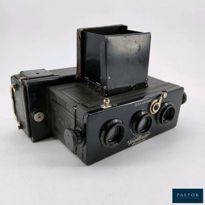 un vieil appareil photo noir surmonté d'une boîte