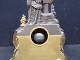 a clock with a statue of a man on top of it