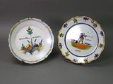 two small plates with designs on them sitting on a table