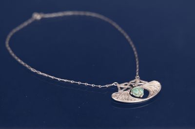 un gros plan d'un collier en argent orné d'une pierre verte
