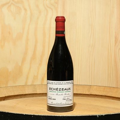 a bottle of wine sitting on top of a barrel