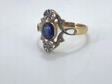 a close up of a gold ring with a blue stone