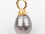 a close up of a black pearl pendant on a white surface