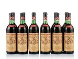 six bottles of wine are lined up on a white surface