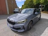 une BMW M140i grise garée sur le bord de la route