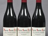 three bottles of red wine sitting on a table next to each other