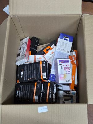 une boîte en carton remplie d'objets divers, posée par terre