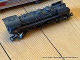 a toy train sitting on a wooden table next to a laptop