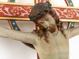 a statue of jesus on the cross with a cross in the background