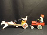 a small wooden toy horse pulling a wagon with a man on it