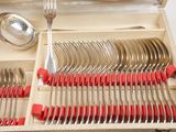 silverware in a wooden box with red handles and spoons